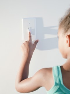 Mixed race girl turning off light