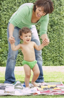 Hispanic mother helping daughter learn to walk
