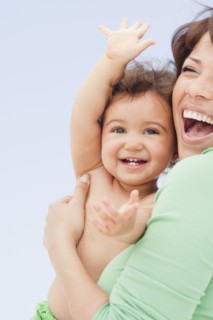 Laughing Hispanic woman holding daughter