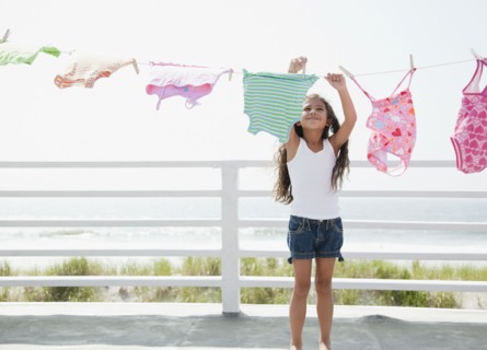 Hispanic girl hanging laundry to dry