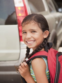 Smiling Hispanic girl carrying backpack
