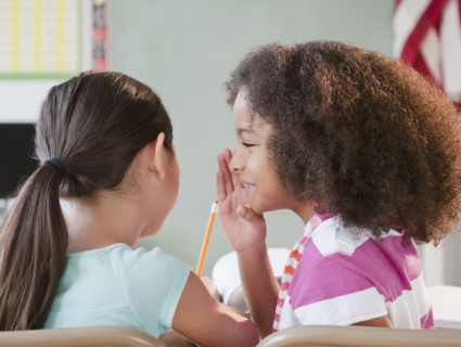 School girl whispering to friend