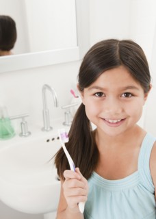 Mixed race girl holding toothbrush