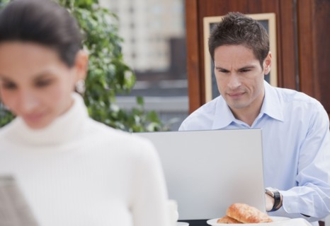 Hispanic businessman working in cafe