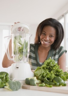 Mixed race woman blending vegetables