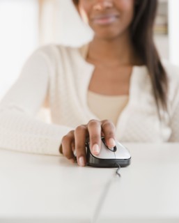 Mixed race woman using computer mouse