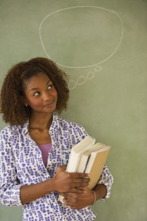Mixed race woman standing next to thought bubble on blackboard