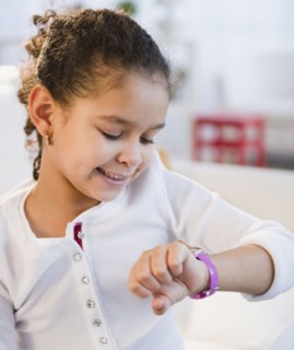 Hispanic girl looking at wristwatch