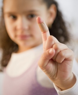 Hispanic girl with bandage on finger