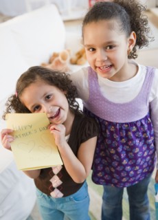 Hispanic sisters with Father's Day card
