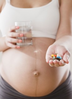 Pregnant Hispanic woman with handful of pills