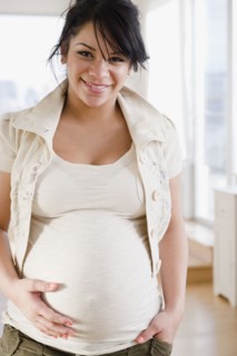 Pregnant Hispanic woman holding stomach