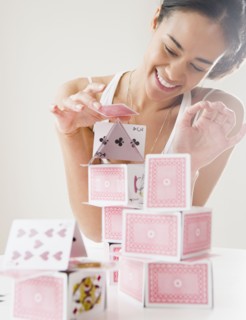 Mixed race woman building house of cards