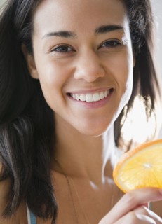 Mixed race woman holding orange slice