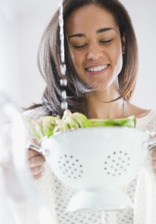 Mixed race woman rinsing spinach