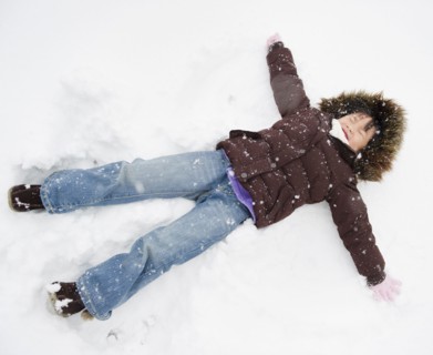 Chinese girl making snow angel