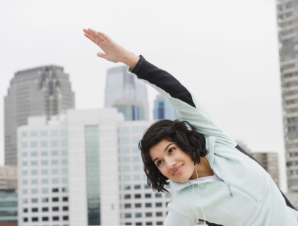 Hispanic woman stretching in city