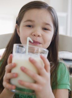 Mixed race girl drinking milk