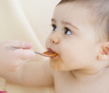 Mixed race baby boy eating