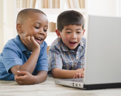 Smiling boys enjoying using a laptop