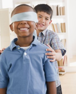 Boy spinning friend wearing blindfold