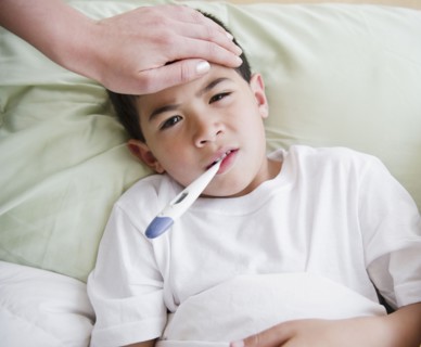 Sick mixed race boy having is temperature taken