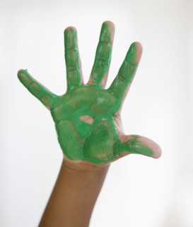 Black boy with green paint on hand