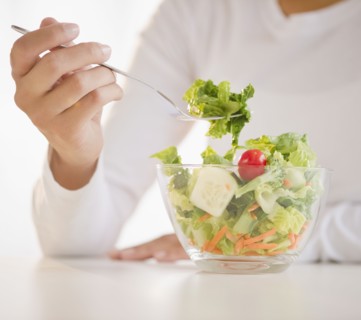 Mixed race woman eating salad