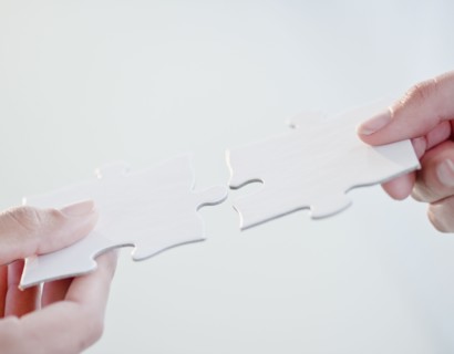 Hands connecting jigsaw puzzle pieces