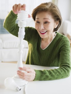 Japanese woman replacing energy efficient light bulb