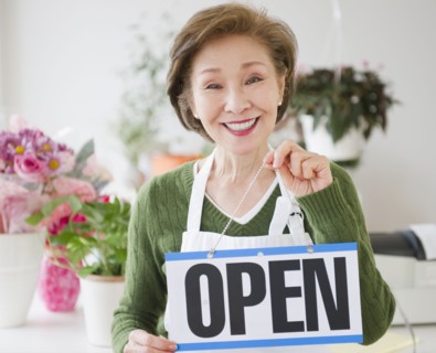 Japanese florist holding open sign