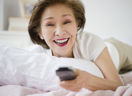 Japanese woman watching television in bed