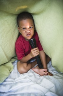African American boy making fence in tent