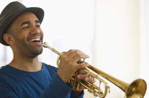 Mixed race man playing trumpet