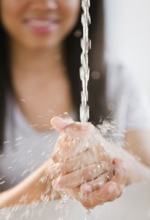 Close up of mixed race teenage girl washing hands in water