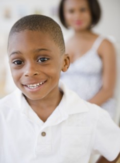 Smiling Black boy with mother in background