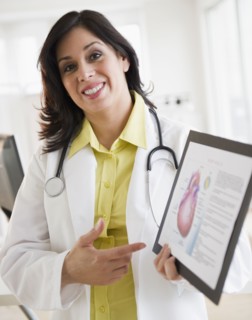 Smiling Hispanic doctor holding up diagram of heart