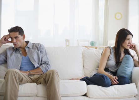 Angry mixed race couple having argument on sofa