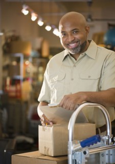 African American deliveryman with clipboard and boxes