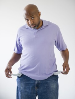 Sad African American holding out empty pockets