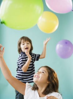 Hispanic brothers and sisters playing with balloons