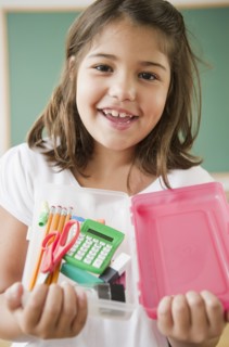 Hispanic girl holding school supplies