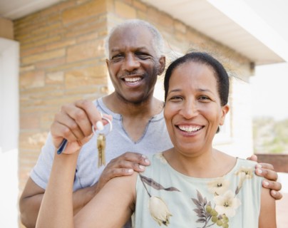 Proud Black couple holding keys to new home