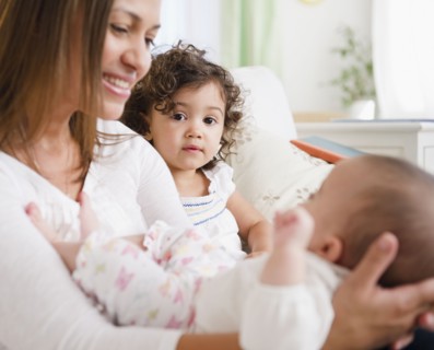 Smiling mother sitting with daughters