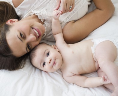 Mother laying on bed with baby