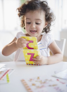 Mixed race girl playing with alphabet cards