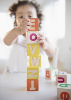 Mixed race girl stacking blocks