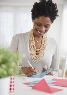 Black woman writing on birthday card