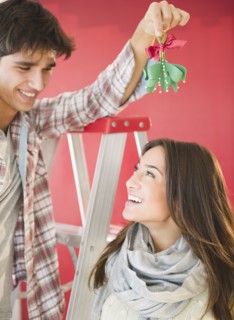 Man holding mistletoe over wife's head