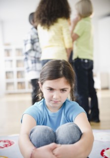 Lonely girl ignoring friends playing